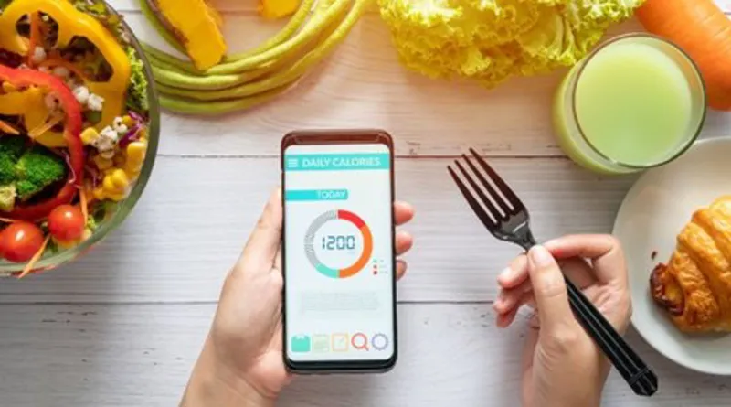 calories-counting-diet-food-control-and-weight-loss-concept-woman-using-calorie-counter-application-on-her-smartphone-at-dining-table-with-salad-fruit-juice-bread-and-vegetable.jpg